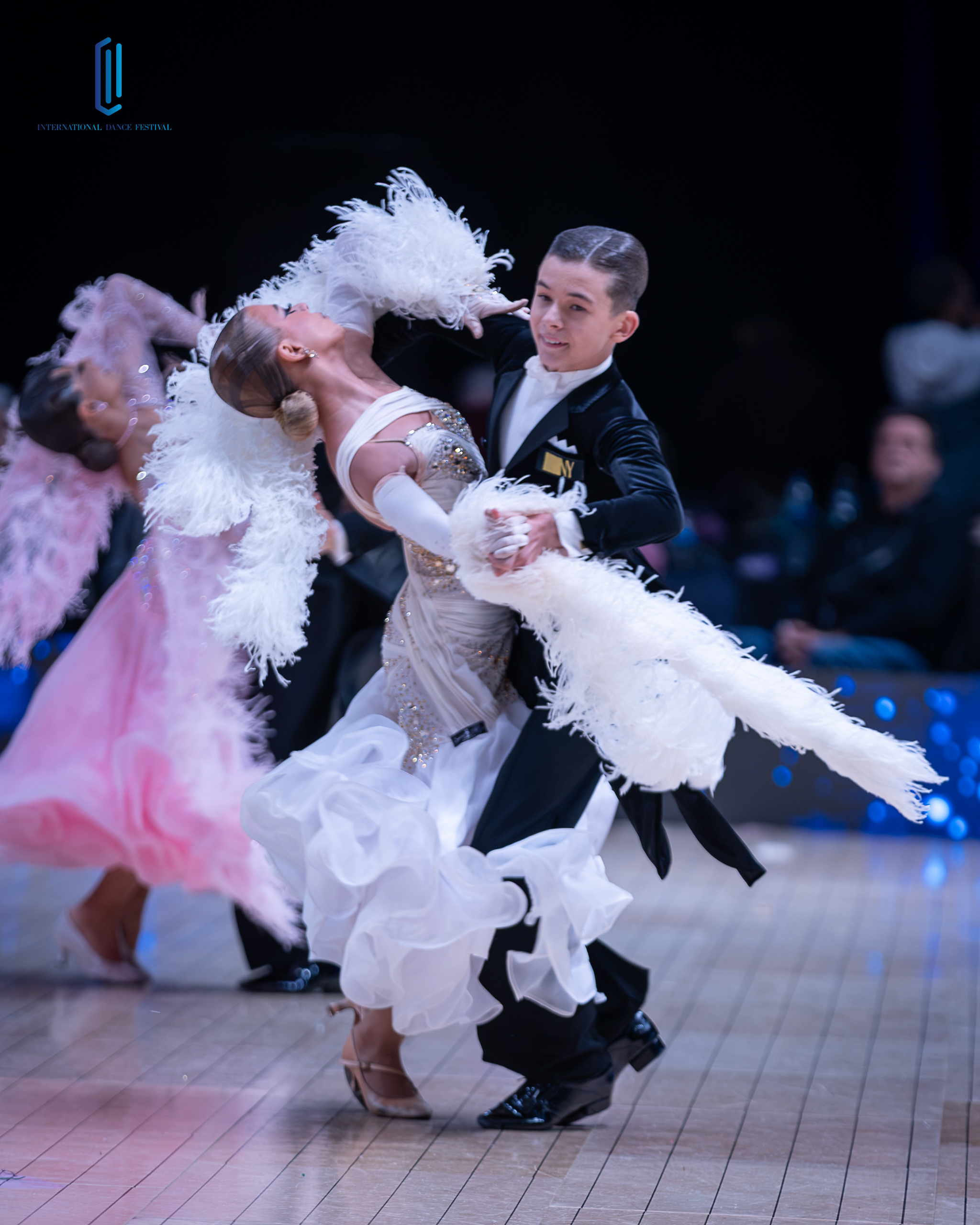 Black and white close-up of a dancer leaning back amid soft feathers and lights
